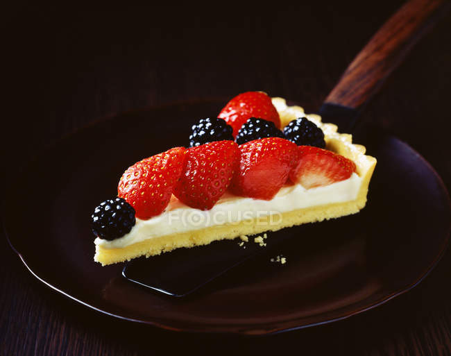 Tranche de tarte à la fraise et à la mûre sur assiette — Photo de stock