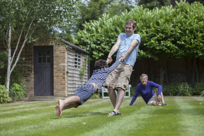 Семья из трех поколений валяет дурака в саду — стоковое фото