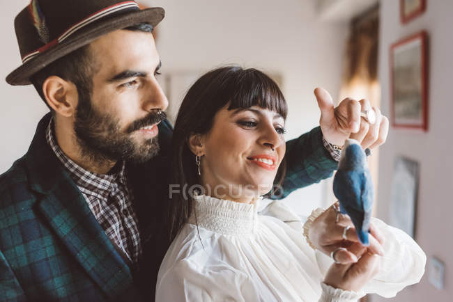 Junges Paar spielt mit Haustier Vogel drinnen — Stockfoto