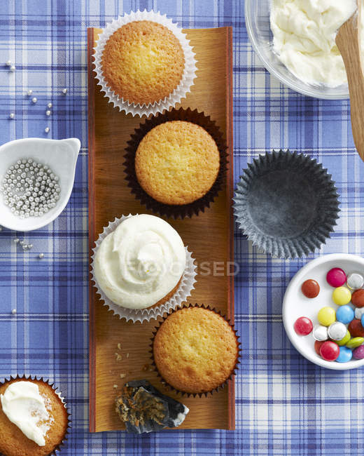 Cupcakes de vainilla con selección de ingredientes y decoración - foto de stock