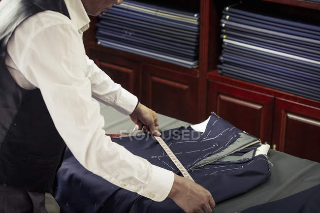 Tailor measuring garment in tailors shop — Stock Photo