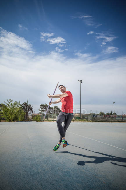 Hombre lanzando jabalina en campo de deportes - foto de stock