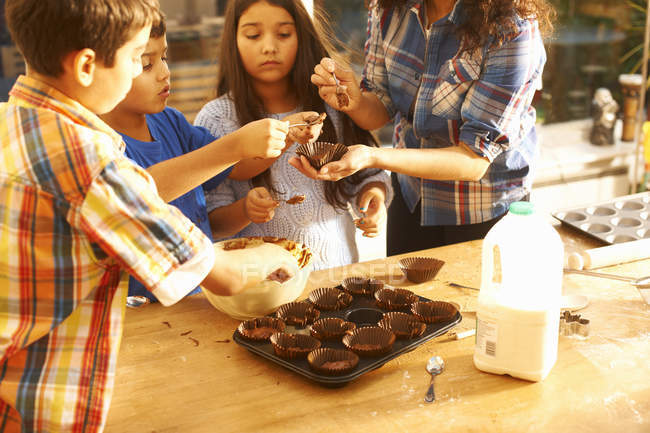 Mother and children baking in kitchen at home — Stock Photo
