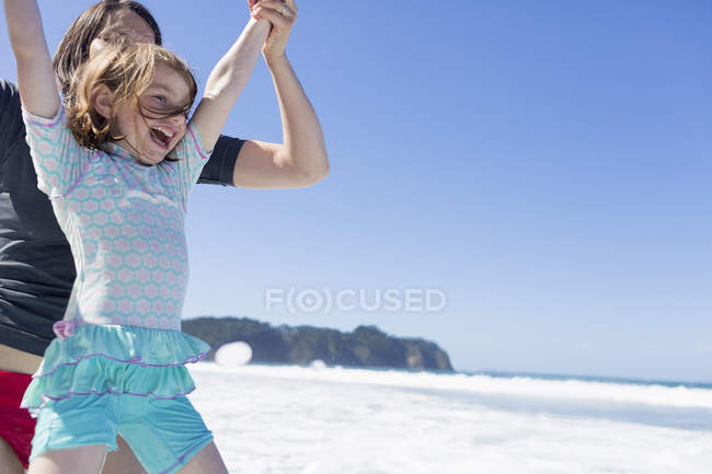 Madre e figlia che saltano in mare, Acqua calda Spiaggia, Baia delle Isole, Nuova Zelanda — Foto stock
