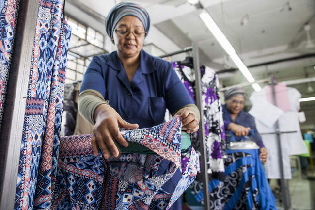 Trabalhadores de engomar vestido na fábrica de vestuário — Fotografia de Stock