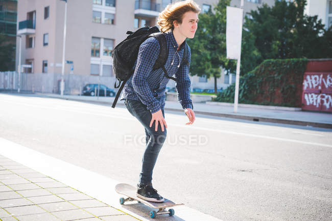 Junger männlicher Skateboarder skateboardet auf Gehweg — Stockfoto