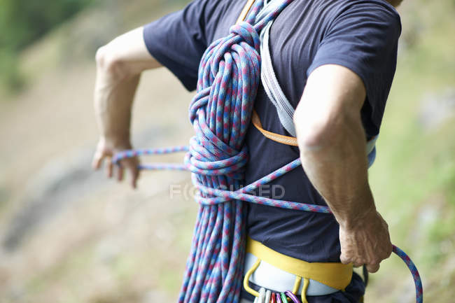 Vista recortada del escalador que lleva la cuerda de escalada en la espalda - foto de stock