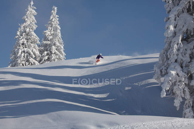 Snowboarder cabalgando por la montaña, Brixental, Austria - foto de stock