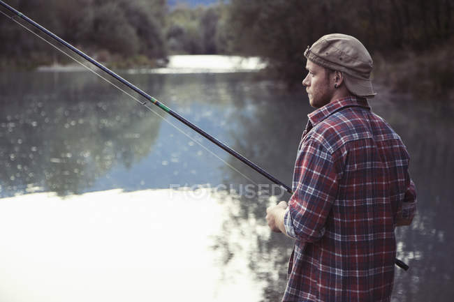 Young man fishing in lake, Premosello, Verbania, Piemonte, Italy — Stock Photo