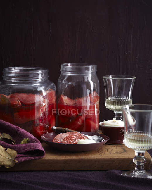 Prato e frascos de marmelo caseiro escalfado na tábua de corte — Fotografia de Stock