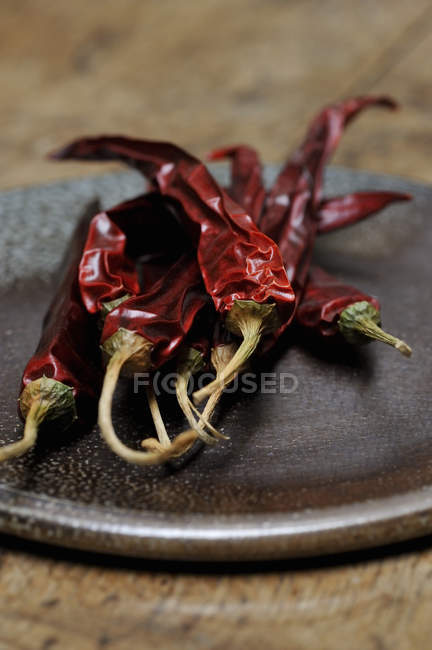 Pimentas vermelhas secas no prato, tiro de perto — Fotografia de Stock