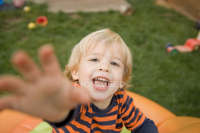 Young boy reaching towards camera — Stock Photo