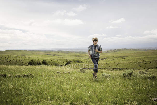 Teenage boy running in landscape, Cody, Wyoming, USA — Stock Photo