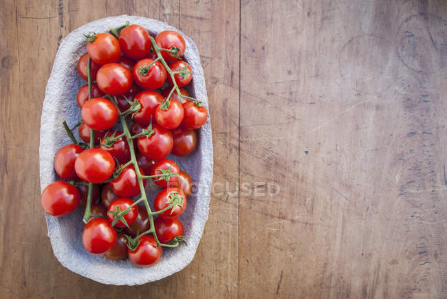 Вид зверху на помідори вишневої лози в картонній тарі — стокове фото