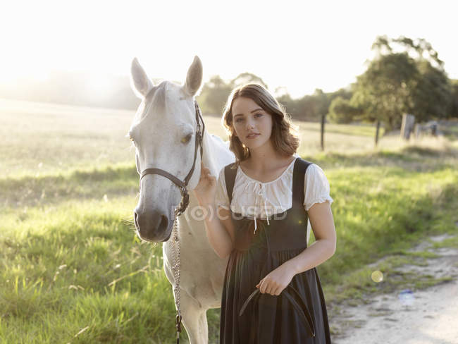 Portrait of teenage girl and her grey horse — Stock Photo