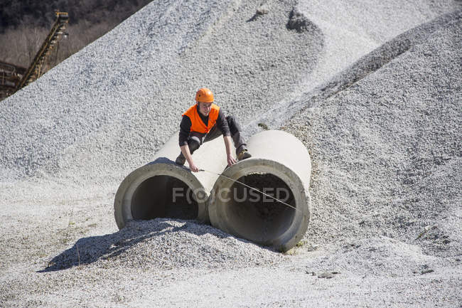 Quarry worker measuring industrial pipes at quarry — Stock Photo