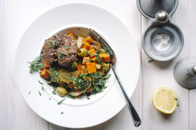 Plato de carne y verdura con tenedor en plato - foto de stock