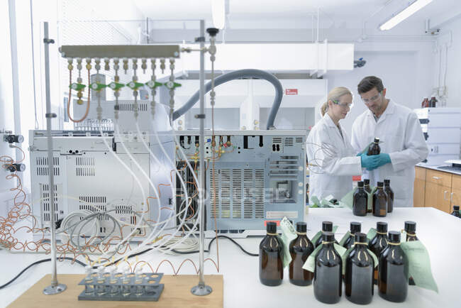 Trabajadores de laboratorio que prueban muestras de aceite - foto de stock