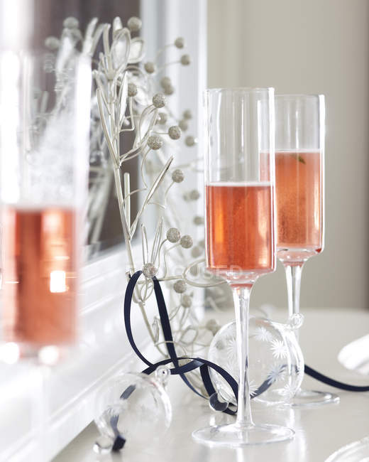Champagne flauti di champagne rosa su caminetto con decorazioni natalizie — Foto stock