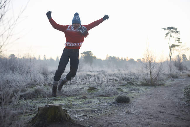 Чоловік стрибає в сільській зимовій сцені — стокове фото