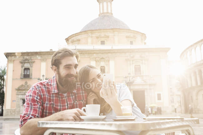 Young couple having coffee in sidewalk cafe, Plaza de la Virgen, Valencia, Spain — Stock Photo