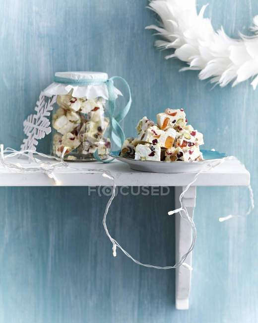 Rocky road dessert in glass jar and stacked on plate on shelf — Stock Photo