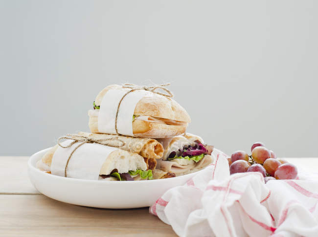 Plate of ciabata sandwiches and fresh grapes — Stock Photo