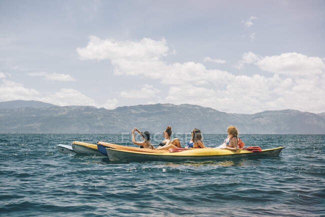 Quatre jeunes amies kayak sur le lac Atitlan, Guatemala — Photo de stock