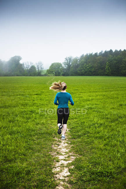 Mulher madura correndo no campo — Fotografia de Stock