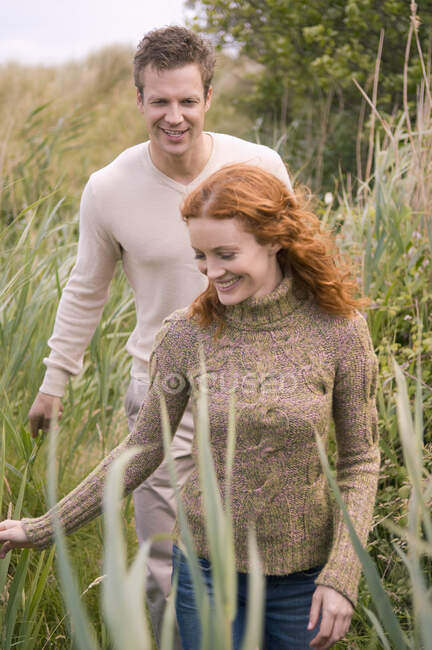 Couple se promenant sur un terrain herbeux — Photo de stock