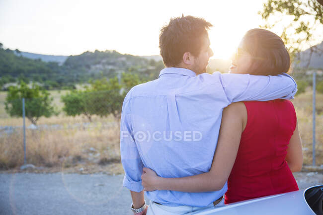 Vista traseira do jovem casal romântico ao pôr do sol, Maiorca, Espanha — Fotografia de Stock