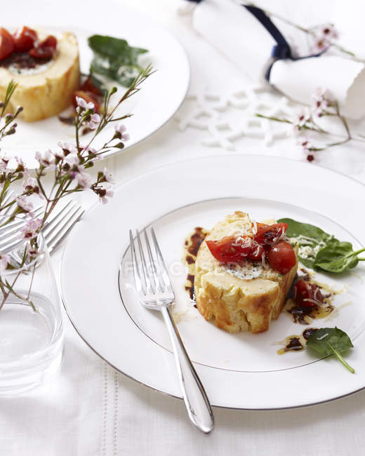 Goat cheese roulade with tomatoes and basil on elegant plate — Stock Photo