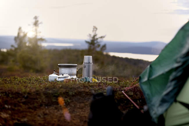 Coffee flask and tent on green grass — Stock Photo