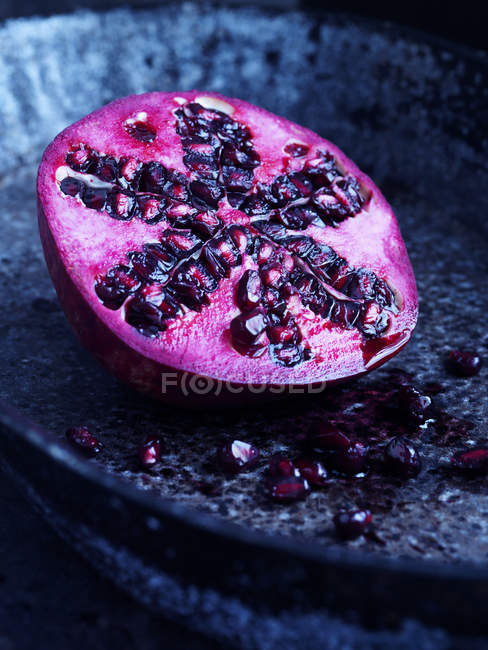 Pomegranate on blue plate — Stock Photo