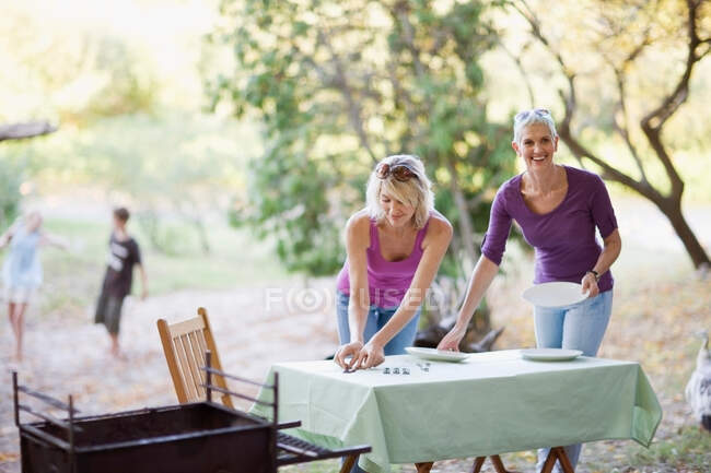 Les femmes mettent la table à l'extérieur — Photo de stock