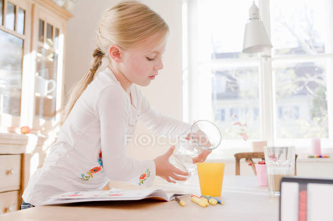 Дівчинка виливає склянку соку — стокове фото