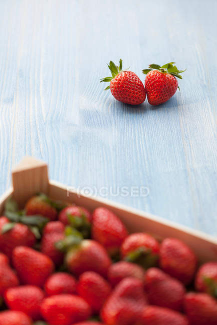 Pair of strawberries outside crate — Stock Photo