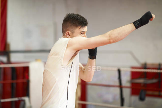 Боксер, практикующий в боксерском ринге — стоковое фото