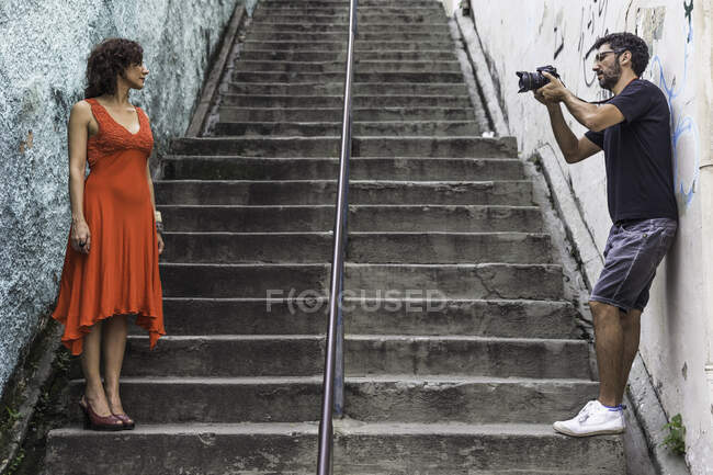 Detrás de las escenas de una sesión de moda urbana con modelo femenino y fotógrafo masculino - foto de stock