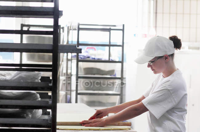 Baker cutting bread dough — Stock Photo