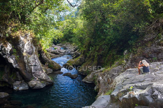 Жіночий туристичних на фотографування тропічних лісах річку, острів Реюньон скелях — стокове фото