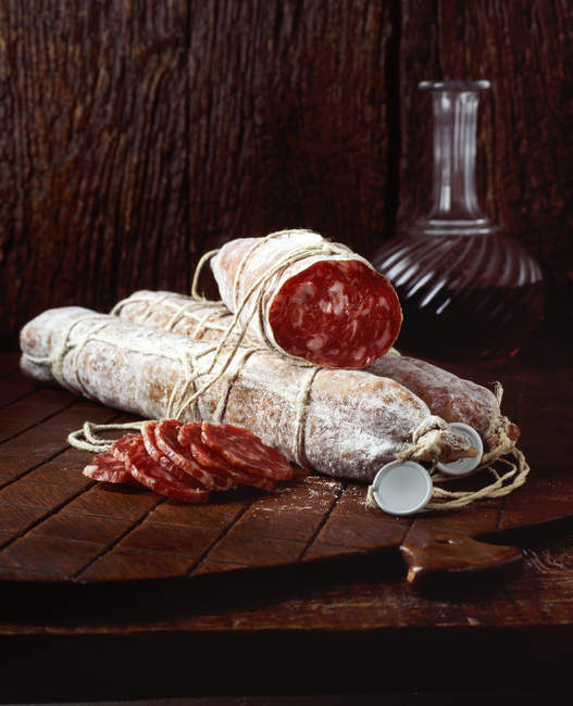 Spanish chorizo sausage on wooden chopping board — Stock Photo