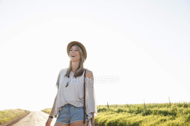 Mid adult woman on country road, laughing — Stock Photo