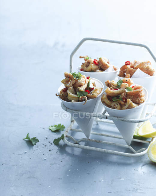 Fried chilli squid portions in paper cones — Stock Photo