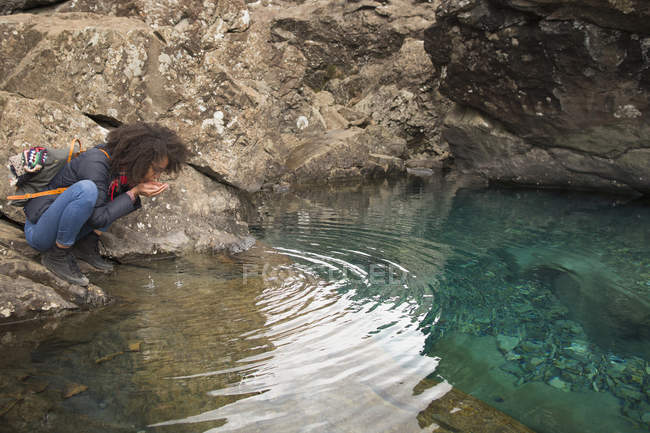 Woman drinking water from cupped hands, Fairy Pools, Isle of Skye, Hebrides, Scotland — Stock Photo
