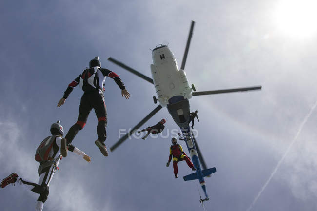 Vista ad angolo basso di elicottero e sei paracadutisti caduta libera, Siofok, Somogy, Ungheria — Foto stock