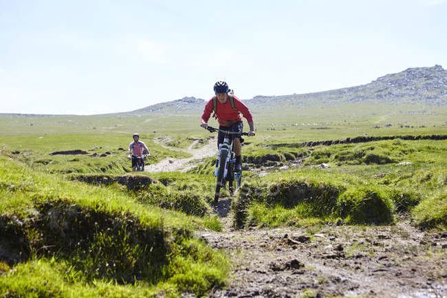 Cyclists cycling down hillside — Stock Photo