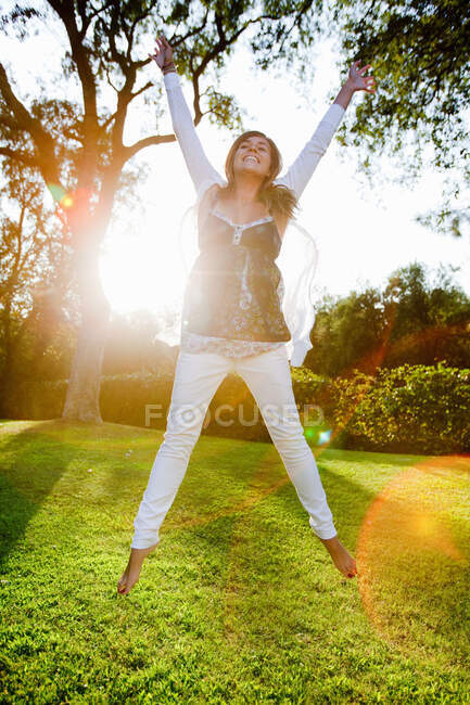 Adolescente gurl pulando no jardim — Fotografia de Stock