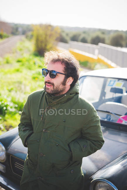 Homme adulte moyen devant une voiture vintage — Photo de stock