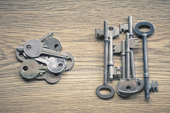 Верхний вид серебряных металлических ключей на деревянной поверхности — стоковое фото